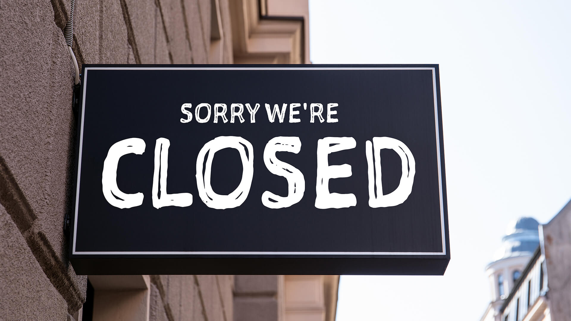 Sign outside a retail business that says "sorry we're closed"