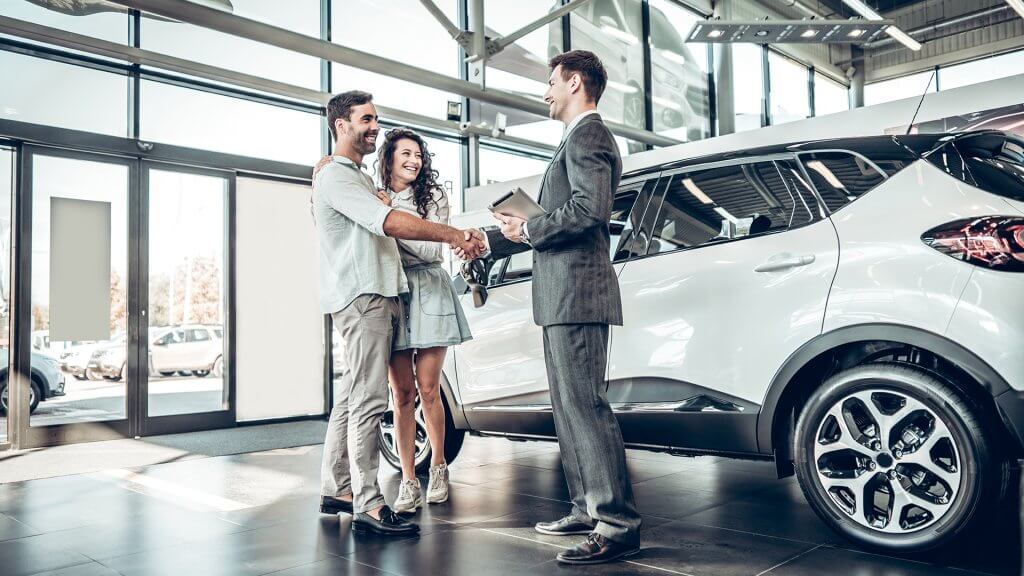 Young couple talking to a car salesman