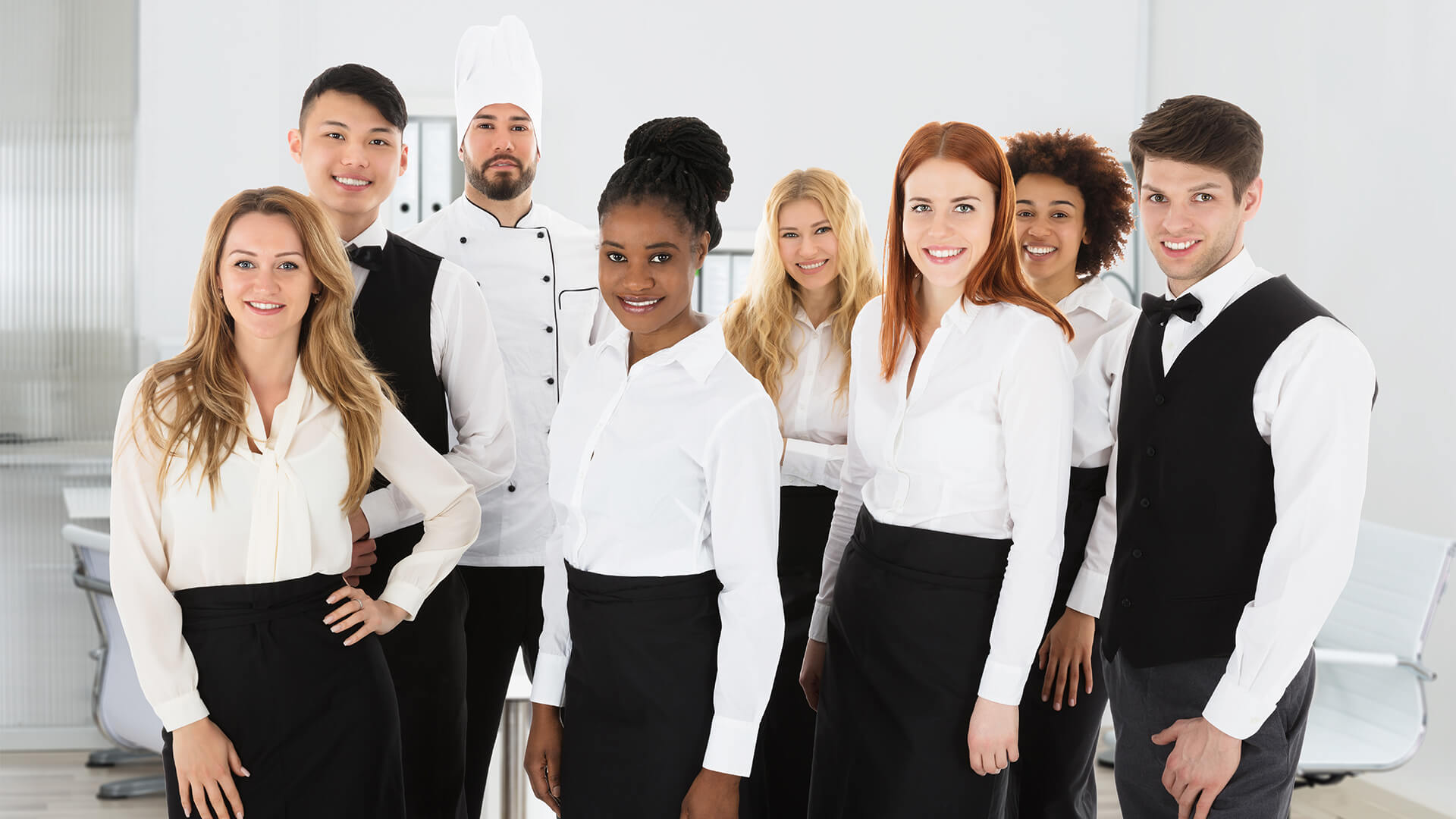 Restaurant employees including chefs and waiters in black and white uniforms