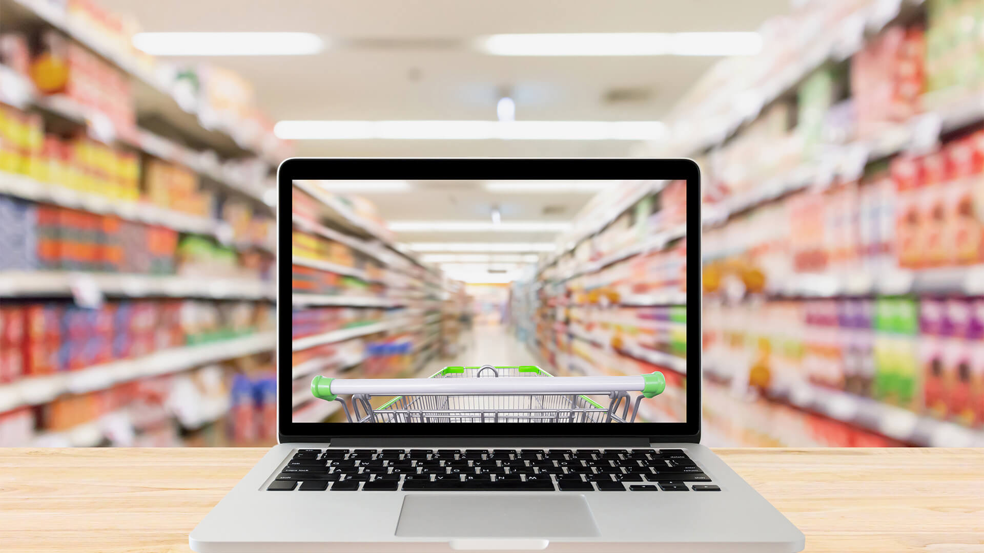 laptop computer on wood table with supermarket aisle blurred background online shopping concept