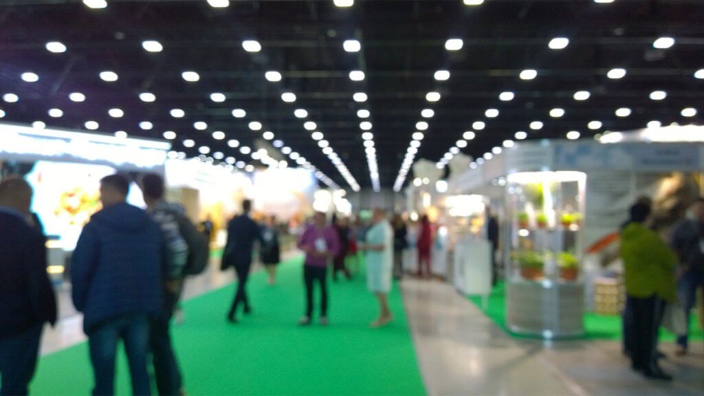 Out of focus trade show floor with people walking about