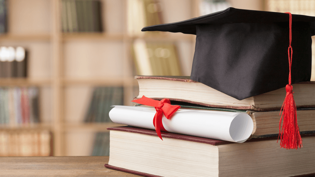 Books, degree scroll diploma and graduation cap