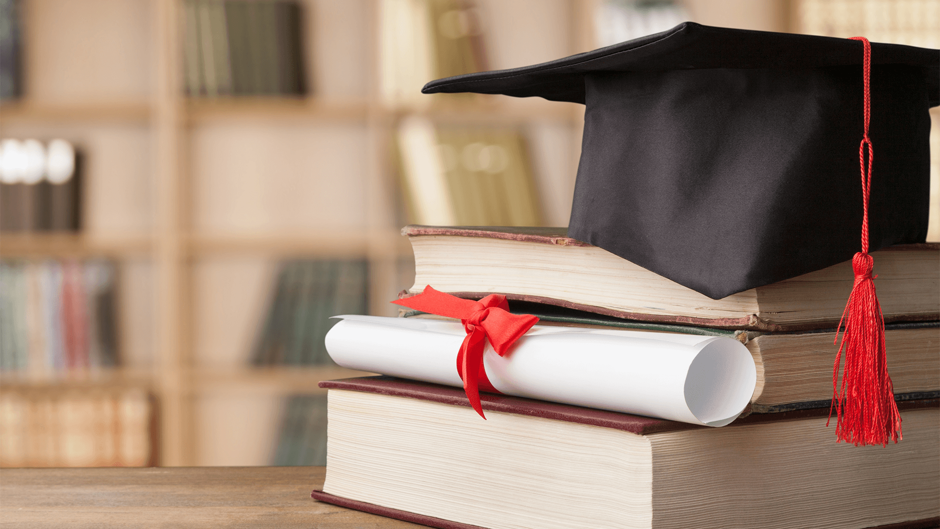 Books, degree scroll diploma and graduation cap