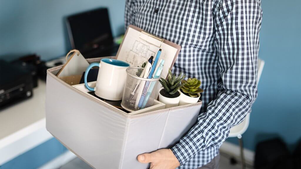 man holding a box with personal items stuff leaving the office