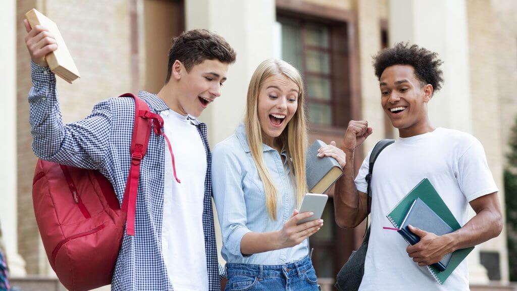 Three teenage friends celebrating exam results