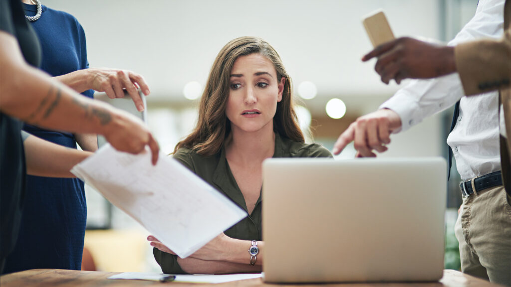 Cropped shot of a young businesswoman feeling overwhelmed by her colleagues in the office