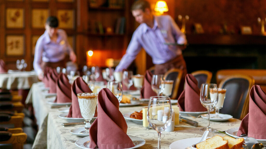 Waiters prepare a table for breakfast