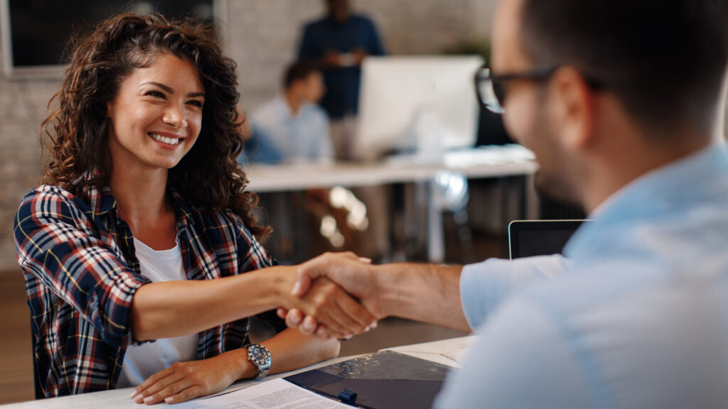 Young woman signing contracts and handshake with a manager