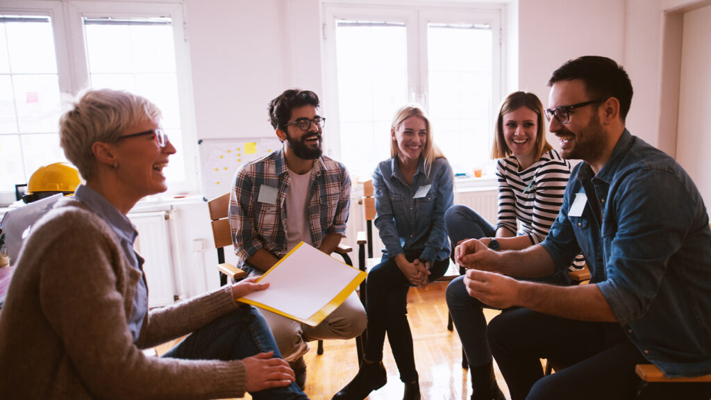 group of people sitting in circle talking