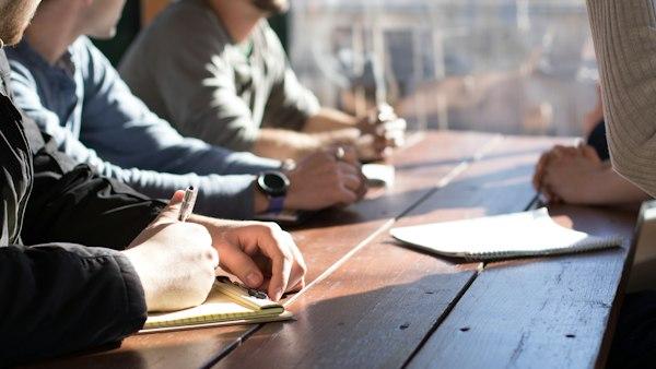 Business team in a meeting around a table with laptops and notebooks